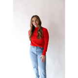 Person rocking the Sherry Sweater in Bright Red with light blue jeans for everyday style