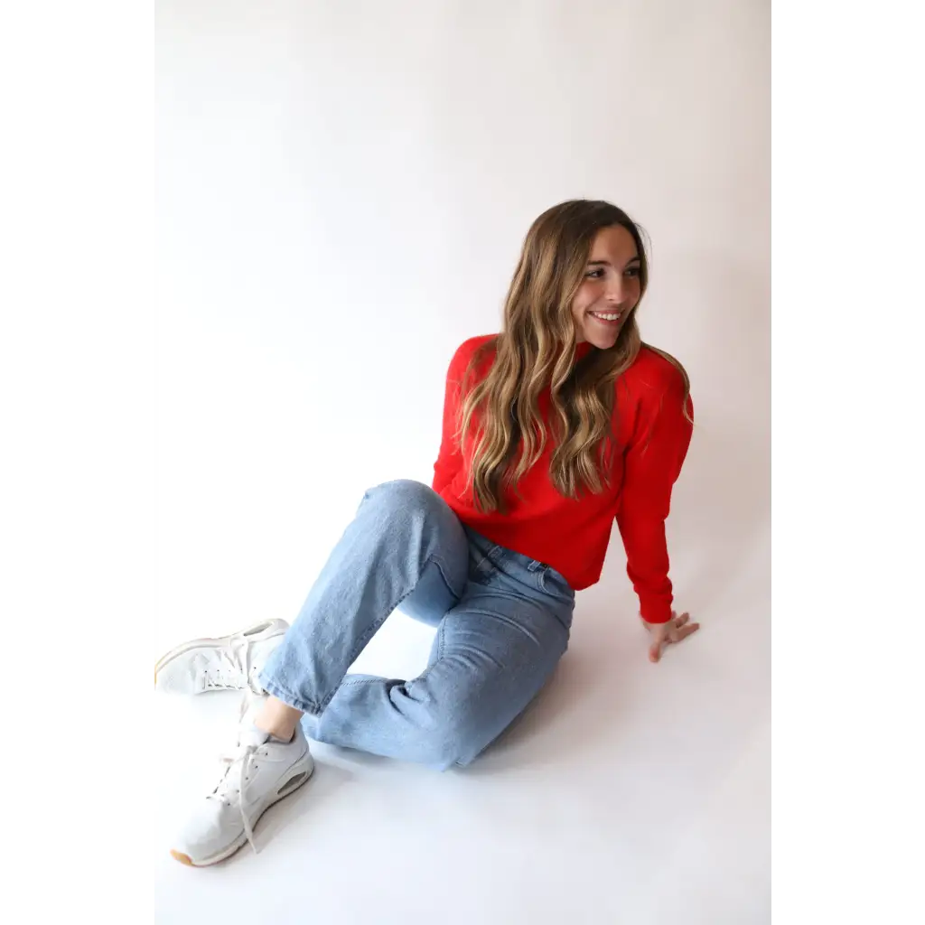 Person in a Sherry Sweater, bright red, and light blue jeans for your everyday wardrobe