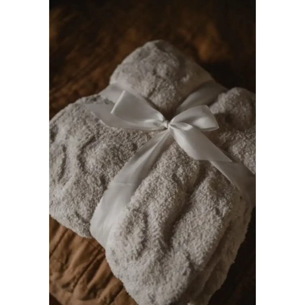 Folded white towel tied with a ribbon, perfect for warmest snuggles included