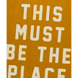 Text art on mustard background featured on This Must Be the Place Camp Flag, perfect for stylish womens clothes