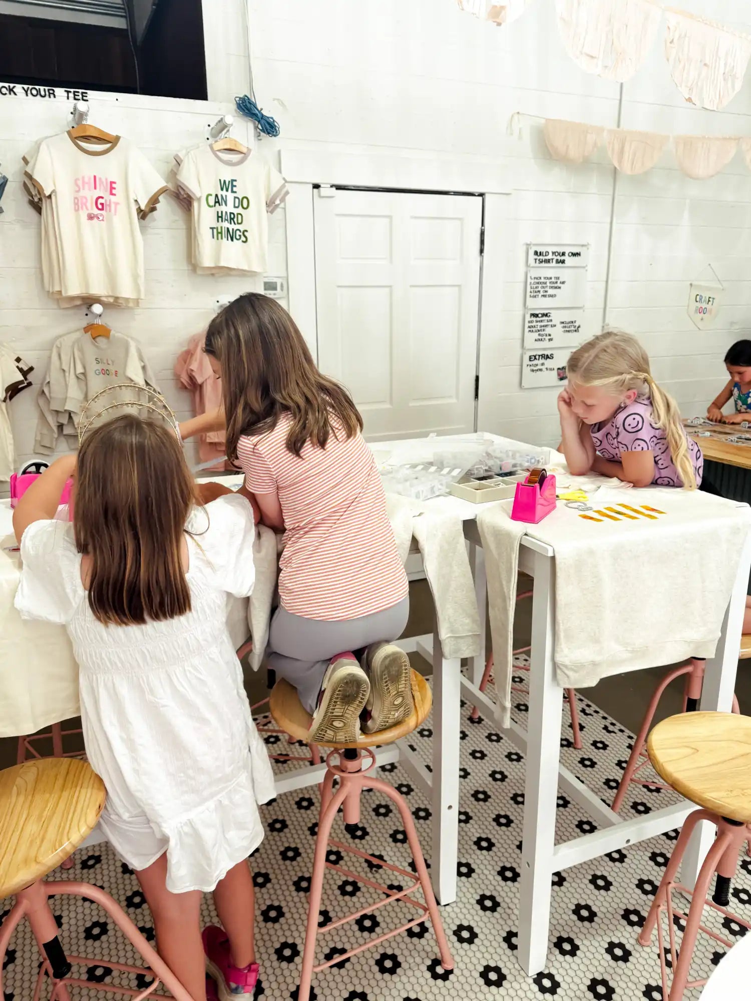 Three young girls engaged in a creative activity at a table.