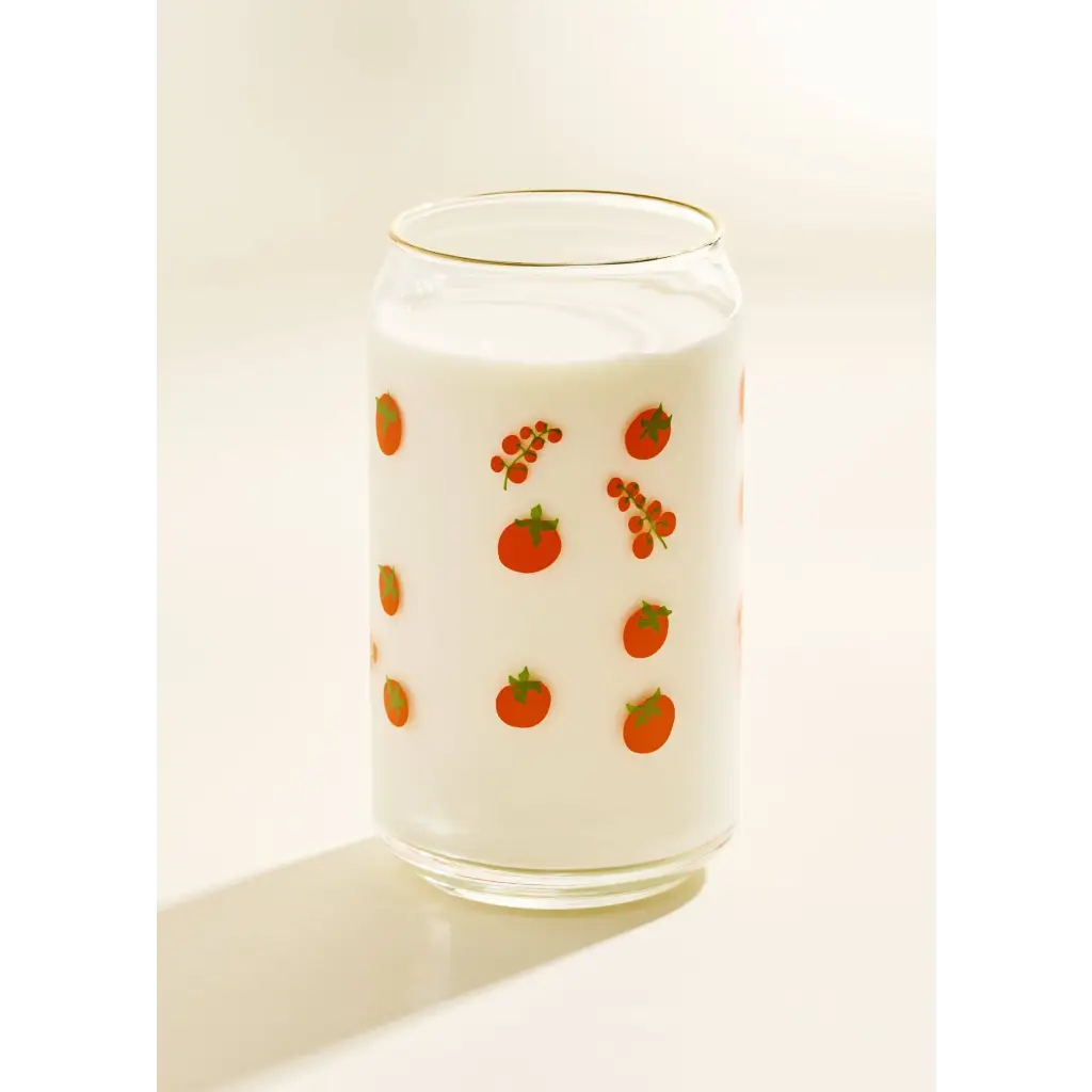 Glass can-shaped tumbler with fruit pattern and white drink, perfect for stylish womens clothes