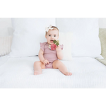 Cute baby pink romper with ruffles, florals, and Turnip Crinkle Baby Teether beaded ring