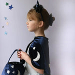 Young girl in Velvet Twilight Cauldron Bag with starry cape and unicorn headband