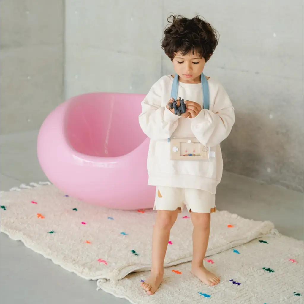 Child in white outfit with blue suspenders enjoying Wakka Retro Water Game fun