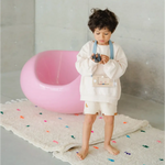 Child in white outfit with blue suspenders enjoying Wakka Retro Water Game fun