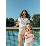 Two friends in matching white outfits by a tennis net rocking Wave Wash Fleece Shorts