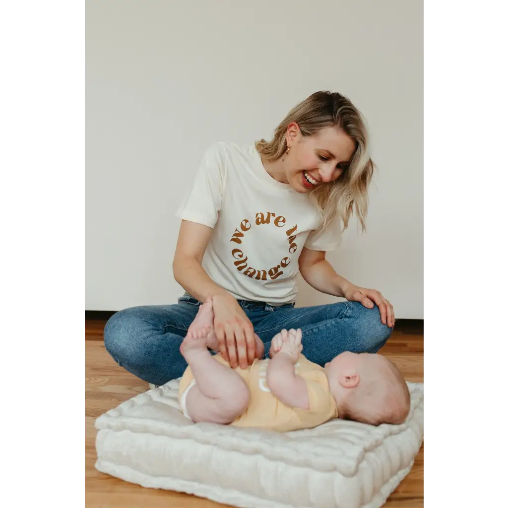 Baby enjoying a gentle massage on a white cushion by a change graphic t-shirt design