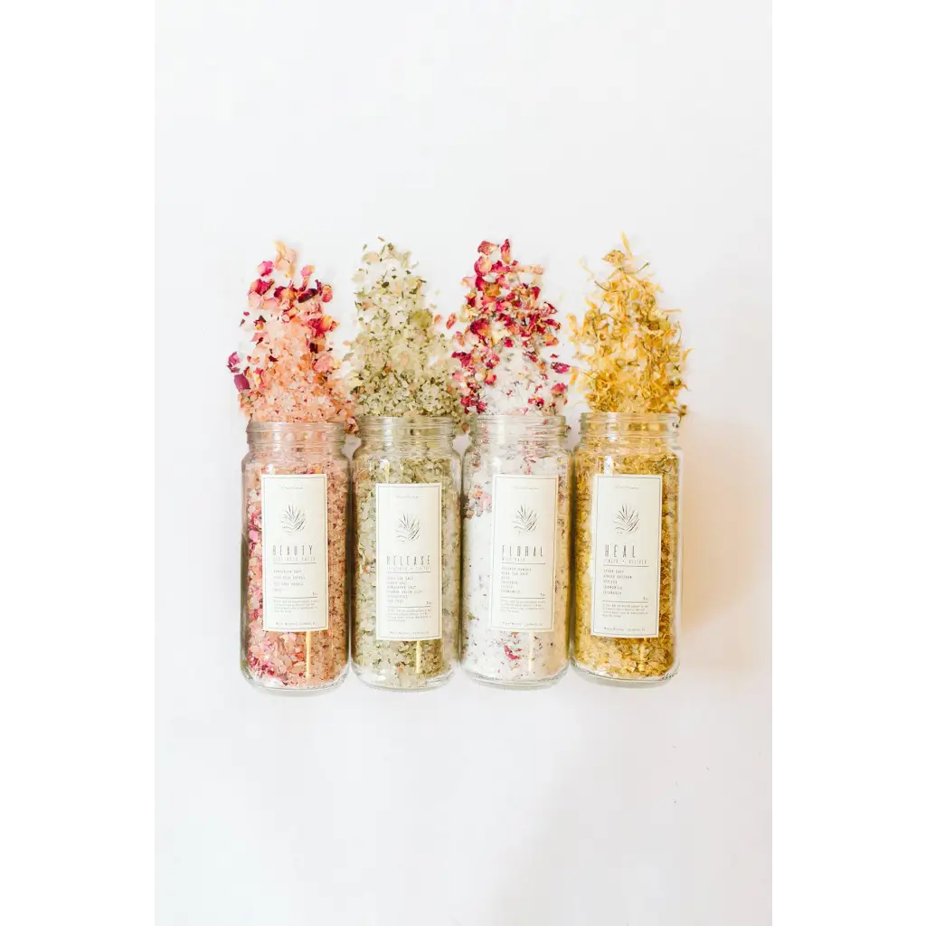 Four WildFlora bath salts jars with floral petals