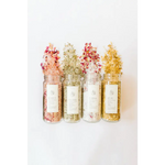 Four WildFlora bath salts jars with floral petals