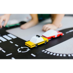 Yellow taxi toy cab made of solid beech wood on a fun checkered road track