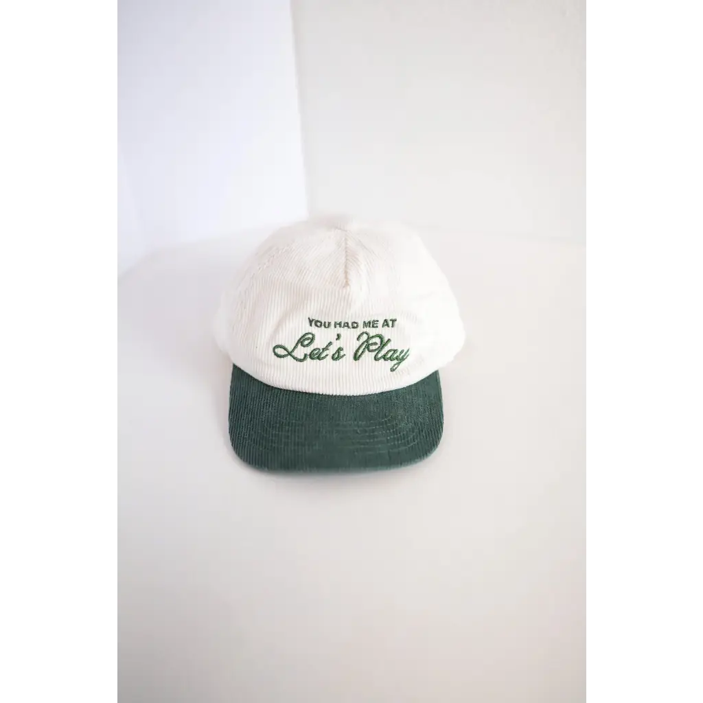 White and green embroidered kids trucker hat with Let’s Play text for fun times