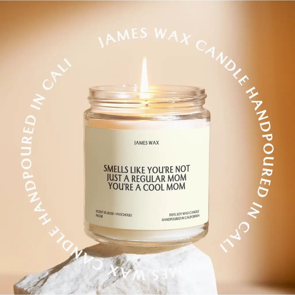 Lit white candle in a jar, labelled cool mom, with quality white tea scent in small batches